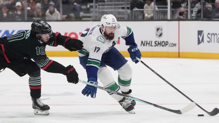 Vancouver Canucks defenceman Filip Hronek (17) moves the puck against Seattle Kraken centre Matty Beniers (10) during the second period of an NHL hockey game Monday, Dec. 29, 2025, in Seattle. (Lindsey Wasson/AP)