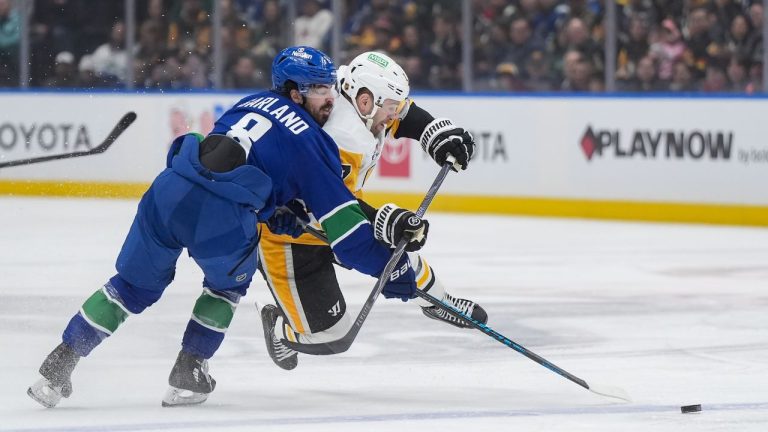 Vancouver Canucks' Conor Garland, front left, and Pittsburgh Penguins' Bryan Rust collide during first period NHL hockey action in Vancouver, B.C., Sunday, Jan. 25, 2026. (Darryl Dyck/CP)