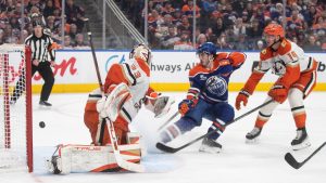 Anaheim Ducks' goalie Ville Husso (33) is scored on as Edmonton Oilers' Matt Savoie (22) and Ducks' Drew Helleson (14) watch the puck go in the net during second period NHL action, in Edmonton on Monday, Jan. 26, 2026. (Jason Franson/CP)