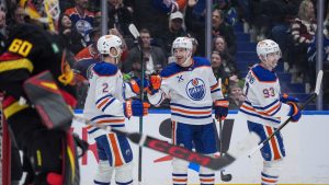 Edmonton Oilers' Evan Bouchard (2), Zach Hyman (18) and Ryan Nugent-Hopkins (93) celebrate Hyman's goal against Vancouver Canucks goalie Nikita Tolopilo (60) during the second period of an NHL hockey game, in Vancouver, on Saturday, January 17, 2026. (Darryl Dyck/CP)