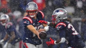 New England Patriots quarterback Drake Maye, left, hands off the ball to running back Rhamondre Stevenson, right, in the second half of an NFL divisional playoff football game against the Houston Texans, Sunday, Jan. 18, 2026, in Foxborough, Mass. (Steven Senne/AP)