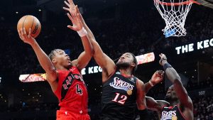 Toronto Raptors forward Scottie Barnes (4) drives to the net as Philadelphia 76ers guard/forward Trendon Watford (12) and teammate Adem Bona (30) defend during first half NBA basketball action in Toronto, Sunday, Jan. 11, 2026. (Frank Gunn/CP)