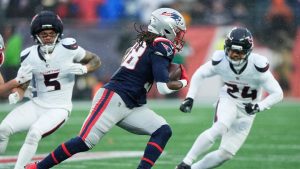 New England Patriots running back Rhamondre Stevenson, middle, runs against Houston Texans safety Jalen Pitre (5) and cornerback Derek Stingley Jr. (24) during the first half of an NFL divisional playoff football game, Sunday, Jan. 18, 2026, in Foxborough, Mass. (Robert F. Bukaty/AP)
