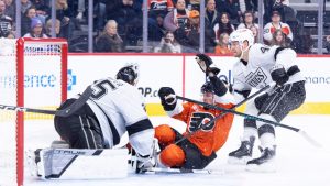 Philadelphia Flyers' Trevor Zegras, centre, slides into Los Angeles Kings' Darcy Kuemper, left, as Joel Armia, right, is behind him during the second period of an NHL hockey game, Saturday, Jan. 31, 2026, in Philadelphia. (Chris Szagola/AP)
