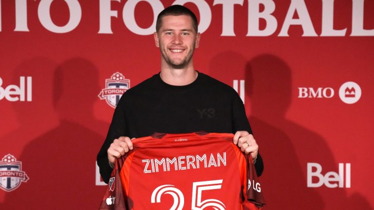 Walker Zimmerman holds a Toronto FC shirt bearing his name, at a news conference in Toronto on Monday January 12, 2026. (Chris Young/CP)