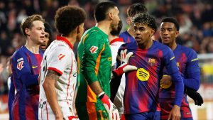 Barcelona's Lamine Yamal argues with Girona's Joel Roca and Axel Witsel during a Spanish La Liga soccer match between Girona and Barcelona in Girona, Spain, Monday, Feb. 16, 2026. (AP Photo/Joan Monfort)