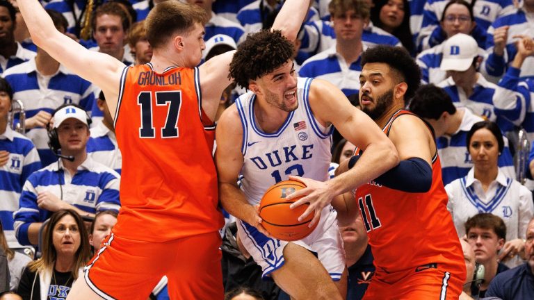 Duke's Cameron Boozer (12) handles the ball between Virginia's Johann Grünloh (17) and Devin Tillis (11) during the first half of an NCAA college basketball game in Durham, N.C., Saturday, Feb. 28, 2026. (Ben McKeown/AP)