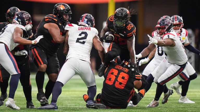 B.C. Lions' James Butler (20) tries to leap over teammate Jarell Broxton (69) who fell in front of him as he runs the ball past Montreal Alouettes' Darnell Sankey (1) and Shawn Oakman (2) during the second half of a CFL football game, in Vancouver, on Saturday, August 16, 2025. THE CANADIAN PRESS/Darryl Dyck
