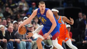 Oklahoma City Thunder guard Shai Gilgeous-Alexander, back, tries to steal the ball from Denver Nuggets center Nikola Joki in the second half of an NBA basketball game, Sunday, Feb. 1, 2026, in Denver. (AP Photo/David Zalubowski)