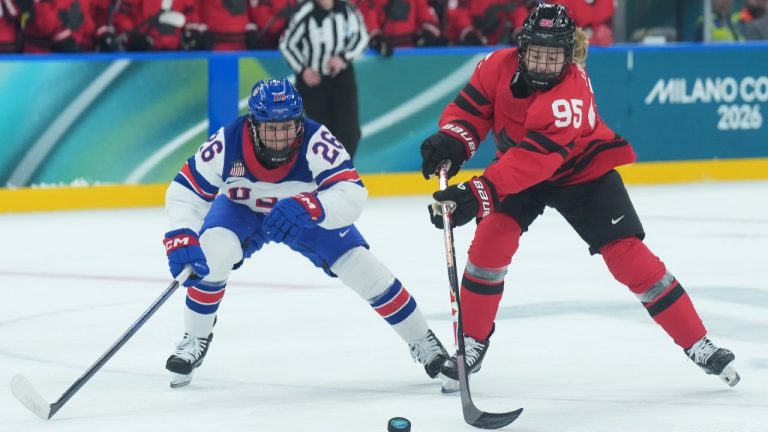 Kendall Coyne (26) of Team United States and Daryl Watts (95) of Team Canada battle for the puck during first period Olympic hockey action at the 2026 Milan Cortina Winter Olympics in Milan, Italy on Tuesday, Feb. 10, 2026. THE CANADIAN PRESS/Nathan Denette