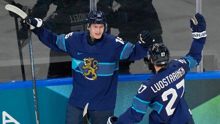Finland's Anton Lundell, left, celebrates with Eetu Luostarinen after scoring the second goal during a preliminary round match of men's ice hockey between Finland and Sweden at the 2026 Winter Olympics, in Milan, Italy, Friday, Feb. 13, 2026. (Hassan Ammar/AP)