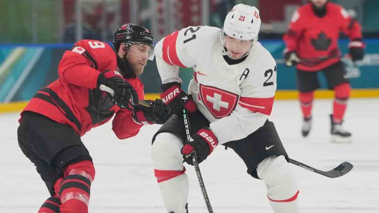 Canada's Sam Bennett, left, challenges Switzerland's Kevin Fiala during a preliminary round match of men's ice hockey between Canada and Switzerland at the 2026 Winter Olympics, in Milan, Italy, Friday, Feb. 13, 2026. (Hassan Ammar/AP)
