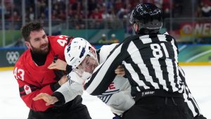 Tom Wilson (43) of Team Canada fights with Pierre Crinon (7) of Team France during third period Olympic hockey action at the 2026 Milan Cortina Winter Olympics in Milan, Italy on Sunday, February 15, 2026. THE CANADIAN PRESS/Nathan Denette