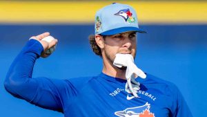 Toronto Blue Jays' Ernie Clement holds a glove in his teeth as he warms up at Spring Training in Dunedin, Fla., on Thursday, Feb. 19, 2026. (Frank Gunn/CP)