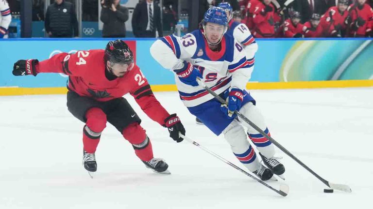 United States' Quinn Hughes (43) moves the puck up ice as Canada's Seth Jarvis (24) defends during second period action for the men's gold medal hockey game at the 2026 Winter Olympics in Milan, on Sunday, February 22, 2026. (Nathan Denette/CP)