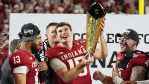 Indiana quarterback Fernando Mendoza (15) holds the trophy after Indiana defeated Miami in a College Football Playoff national championship game, Jan. 19, 2026, in Miami Gardens, Fla. (Lynne Sladky/ AP)