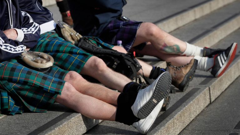 Scottish soccer fans wearing kilts sit on the steps in Trafalgar Square after attending a service to mark Armistice Day in London, Friday, Nov. 11, 2016. (Kirsty Wigglesworth/AP)
