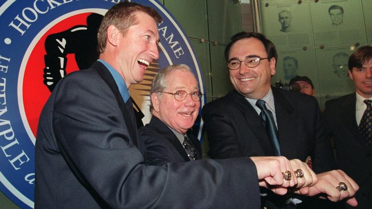 Hockey legends Wayne Gretzky (left), Scotty Morrison and Andy Van Hellemond (right) laugh as they show off their new Hockey Hall of Fame rings during his induction ceremony at the Hall in Toronto on Monday Nov. 22, 1999. (Kevin Frayer/CP)