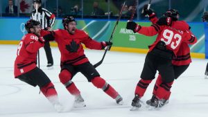 Team Canada players celebrate Canada's Mitch Marner's game-winning goal during overtime of a quarterfinal men's hockey game against Czechia at the 2026 Winter Olympics, in Milan, on Wednesday, Feb. 18, 2026. (Darryl Dyck/CP)