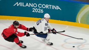 Canada's Devon Toews (7) and France's Alexandre Texier (85) chase the puck in the first period during a preliminary round game of men's ice hockey between Canada and France at the 2026 Winter Olympics, in Milan, Italy, Sunday, Feb. 15, 2026. (AP Photo/Hassan Ammar)