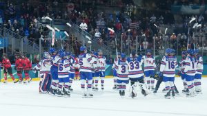 Team United States players celebrate their 5-0 win as Team Canada players skate off the ice at the end of Olympic hockey action at the 2026 Milan Cortina Winter Olympics in Milan, Italy on Tuesday, Feb. 10, 2026. (Nathan Denette/CP)