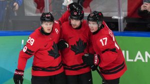 Canada's Sam Reinhart (13) celebrates with Nathan MacKinnon (29) and Macklin Celebrini (17) after Reinhart scored a goal against Finland during the second period of a men's ice hockey semifinal game at the 2026 Winter Olympics in Milan, Italy, Friday, Feb. 20, 2026. (Carolyn Kaster/AP)