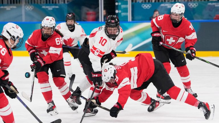 Canada's Sarah Fillier, center, challenges Switzerland's Shannon Sigrist during a preliminary round match of women's ice hockey between Switzerland and Canada at the 2026 Winter Olympics, in Milan, Italy, Saturday, Feb. 7, 2026. (Petr David Josek/AP)