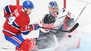 Montreal Canadiens' Nick Suzuki (14) tries to tip the puck past Washington Capitals goaltender Charlie Lindgren (79) during first period NHL hockey action in Montreal, Saturday, Feb. 28, 2026. (Graham Hughes/CP)
