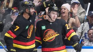 Vancouver Canucks' Jonathan Lekkerimaki (23) and Pierre-Olivier Joseph (7) celebrate Lekkerimaki's goal against the Toronto Maple Leafs during the second period of an NHL hockey game, in Vancouver, on Saturday, January 31, 2026. (Darryl Dyck/CP)