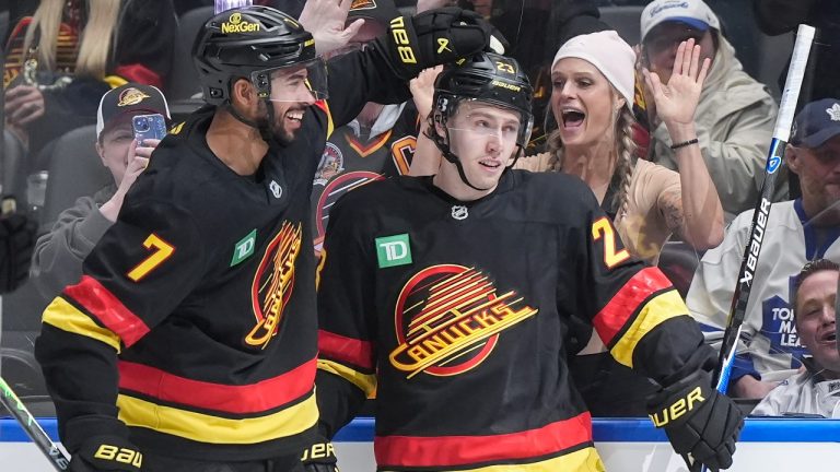 Vancouver Canucks' Jonathan Lekkerimaki (23) and Pierre-Olivier Joseph (7) celebrate Lekkerimaki's goal against the Toronto Maple Leafs during the second period of an NHL hockey game, in Vancouver, on Saturday, January 31, 2026. (Darryl Dyck/CP)