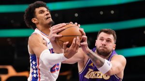 Philadelphia 76ers forward Dominick Barlow, left, and Los Angeles Lakers guard Luka Doncic reach for a rebound during the first half of an NBA basketball game Thursday, Feb. 5, 2026, in Los Angeles. (Mark J. Terrill/AP)