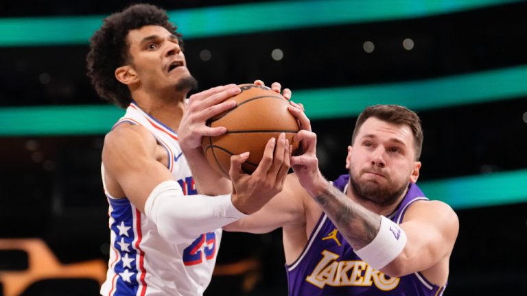 Philadelphia 76ers forward Dominick Barlow, left, and Los Angeles Lakers guard Luka Doncic reach for a rebound during the first half of an NBA basketball game Thursday, Feb. 5, 2026, in Los Angeles. (Mark J. Terrill/AP)