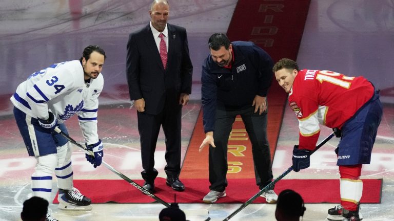 Florida Panthers equipment manager Teddy Richards, second from right, drops a ceremonial puck to Toronto Maple Leafs center Auston Matthews (34) and Florida Panthers left wing Matthew Tkachuk (19) before an NHL hockey game honoring the players on the USA team winning the gold medal at the Milan Cortina Olympics,, Thursday, Feb. 26, 2026, in Sunrise, Fla. Second from left is Florida Panthers president Bill Zito. (AP Photo/Lynne Sladky)