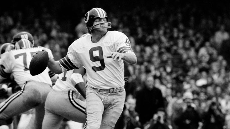 Washington quarterback Sonny Jurgensen looks to pass against the Giants during an NFL football game in 1974. The Washington Commanders will retire Pro Football Hall of Famer Sonny Jurgensenâ€™s No. 9 later this season. The former Washington quarterback and longtime radio broadcaster will be honored in the team's regular-season finale Jan. 7 or 8 against the rival Dallas Cowboys. (AP Photo/File)