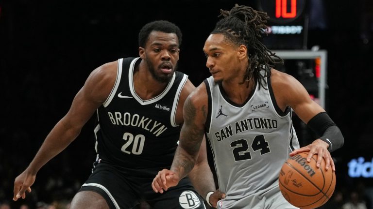 Brooklyn Nets' Day'ron Sharpe (20) defends San Antonio Spurs' Devin Vassell (24) during the second half of an NBA basketball game Thursday, Feb. 26, 2026, in New York. (AP Photo/Frank Franklin II)