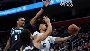 San Antonio Spurs guard Stephon Castle (5) goes to the basket past Detroit Pistons guards Ausar Thompson (9) and Cade Cunningham (2) during the first half of an NBA basketball game Monday, Feb. 23, 2026, in Detroit. (AP Photo/Duane Burleson)