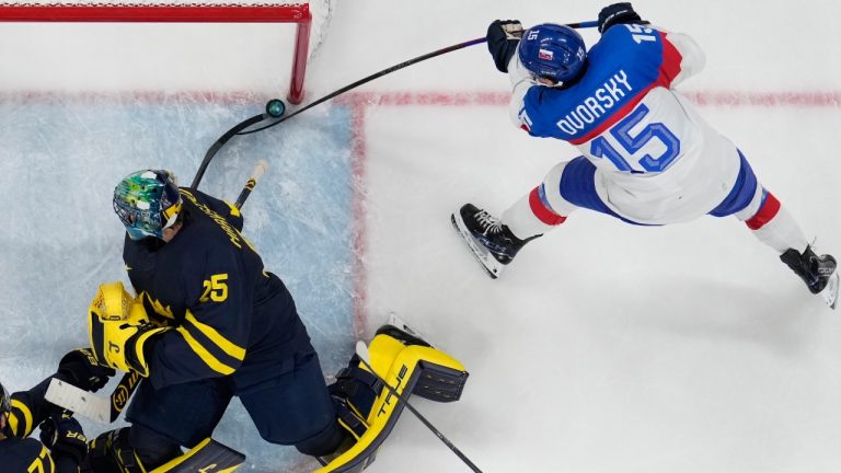 Slovakia's Dalibor Dvorsky, right, scores his side's third goal during a preliminary round game of men's ice hockey between Sweden and Slovakia at the 2026 Winter Olympics, in Milan, Italy, Saturday, Feb. 14, 2026. (AP Photo/Hassan Ammar)