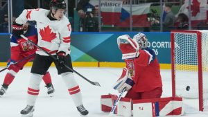 Macklin Celebrini of Team Canada tips the puck past Lukas Dostal of Team Czechia for a goal during first period men's action at the 2026 Milan Cortina Winter Olympics in Milan, Italy, on Thursday, Feb. 12, 2026. (CP/Nathan Denette)