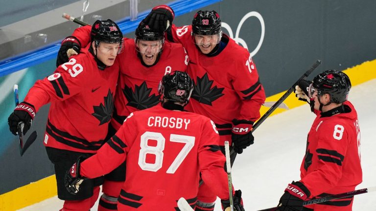 Canada's Connor McDavid celebrates with teammates after scoring his sides first goal during a preliminary round match of men's ice hockey between Canada and Switzerland at the 2026 Winter Olympics, in Milan, Italy, Friday, Feb. 13, 2026. (AP Photo/Hassan Ammar)
