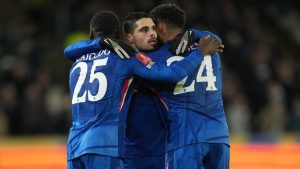 Chelsea's Moises Caicedo, left, and Reece James hug Pedro Neto after he scored during the English FA Cup fourth round soccer match between Hull City and Chelsea in Hull, England, Friday, Feb. 13, 2026. (AP Photo/Jon Super)