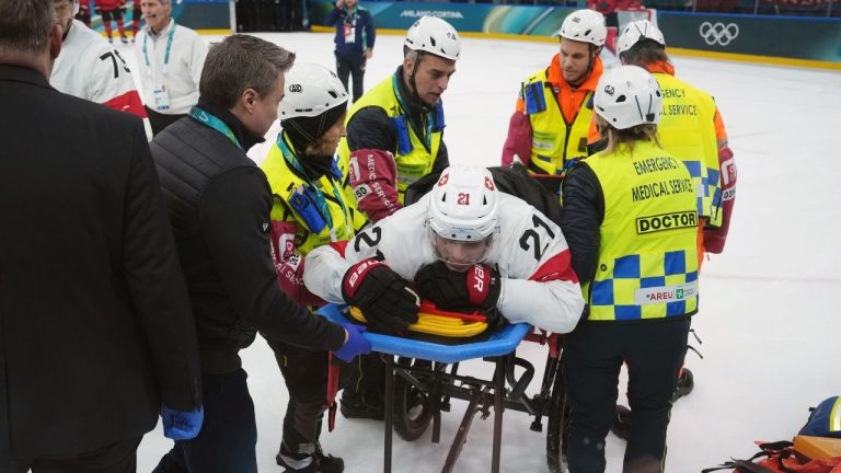 Switzerland's Kevin Fiala (21) is tended to after an injury against Canada during the third period of a preliminary round men's hockey game at the 2026 Winter Olympics, in Milan, on Friday, Feb. 13, 2026. (Darryl Dyck/CP)