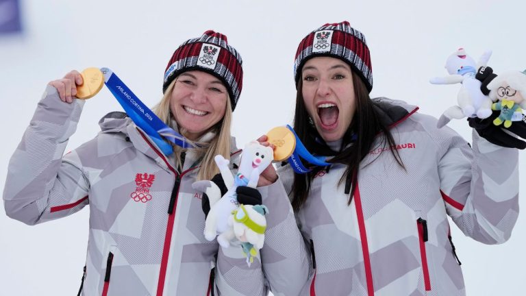 Austria's Ariane Raedler, left, and teammate Austria's Katharina Huber show their gold medals in an alpine ski, women's team combined race, at the 2026 Winter Olympics, in Cortina d'Ampezzo, Italy, Tuesday, Feb. 10, 2026. (AP Photo/Andy Wong)
