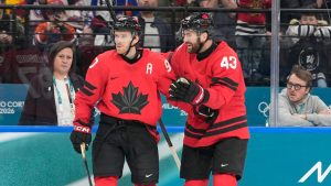 Canada's Connor McDavid (97) celebrates scoring a goal with Canada's Tom Wilson (43) during a preliminary round game of men's ice hockey between Canada and France at the 2026 Winter Olympics, in Milan, Italy, Sunday, Feb. 15, 2026. (AP Photo/Hassan Ammar)