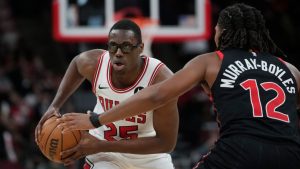 Chicago Bulls forward Jalen Smith (25) handles the ball as Toronto Raptors forward Collin Murray-Boyles (12) defends during the first half of an NBA basketball game Thursday, Feb. 19, 2026, in Chicago. (AP Photo/Erin Hooley)