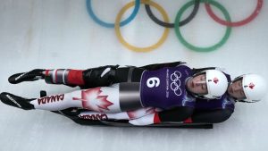 Canada's Beattie Podulsky, left, and Kailey Allan, right, slide down the track during a women's doubles luge training session at the 2026 Winter Olympics, in Cortina d'Ampezzo, Italy, Monday, Feb. 9, 2026. (Aijaz Rahi/AP Photo)