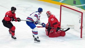 United States' Matt Boldy (12) scores on Canada goalie Jordan Binnington (50) as Canada's Devon Toews (7) defends during the first period of the men's gold medal hockey game at the 2026 Winter Olympics. (Darryl Dyck/THE CANADIAN PRESS)