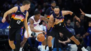 Philadelphia 76ers' VJ Edgecombe, centre, tries to get past Phoenix Suns' Dillon Brooks, right, and Collin Gillespie during the first half of an NBA basketball game Tuesday, Jan. 20, 2026, in Philadelphia. (Matt Slocum/AP)
