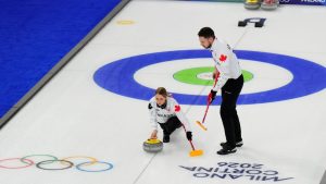 Jocelyn Peterman and Brett Gallant, of Canada, compete during a curling mixed doubles round robin session at the 2026 Winter Olympics, in Cortina d'Ampezzo, Italy, Friday, Feb. 6, 2026. (David J. Phillip/AP Photo)