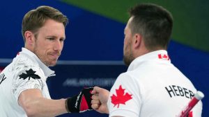 Canada's Marc Kennedy, left, and Ben Hebert react during a men's curling gold medal match between Britain and Canada, at the 2026 Winter Olympics. (Misper Apawu/AP)