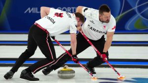Canada's Marc Kennedy, left, and Ben Hebert compete during a men's curling gold medal match between Britain and Canada, at the 2026 Winter Olympics, in Cortina d'Ampezzo. (Misper Apawu/AP)
